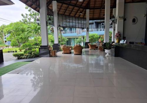 an empty lobby of a building with chairs and tables at Baan Bangsarey Hotels in Bang Sare