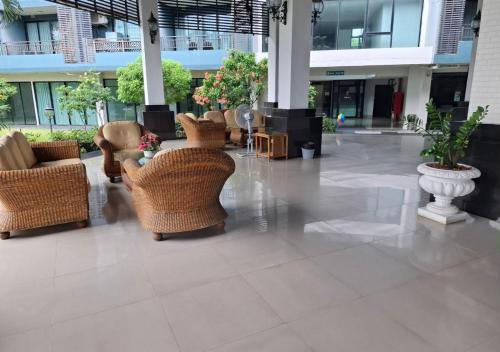 a lobby with couches and chairs in a building at Baan Bangsarey Hotels in Bang Sare