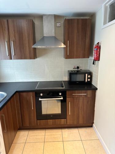 a kitchen with a stove and a microwave at Entire studio flat in Manchester