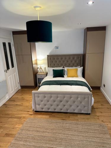 a bedroom with a large bed with a large headboard at Entire studio flat in Manchester