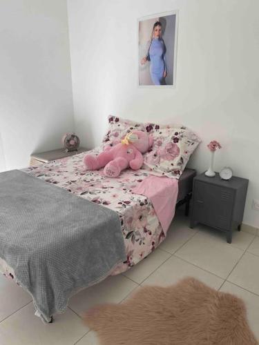 une chambre avec un ours en peluche rose allongé sur un lit dans l'établissement Appartement cosy avec terrasse, à Avignon