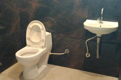 a bathroom with a toilet and a sink at Hotel Maanvad Garh - V One pride by Noww Hotels in Udaipur