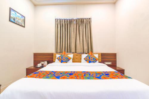 a bedroom with a large white bed with a window at Hotel Maanvad Garh - V One pride by Noww Hotels in Udaipur