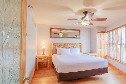 Un dormitorio con una cama y un ventilador de techo. en North Ridge Mountainside Condo, en Biwabik