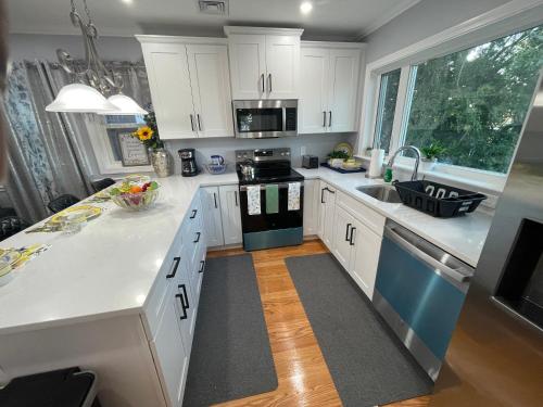 a kitchen with white cabinets and blue appliances at Spectacular Boston City View in Boston