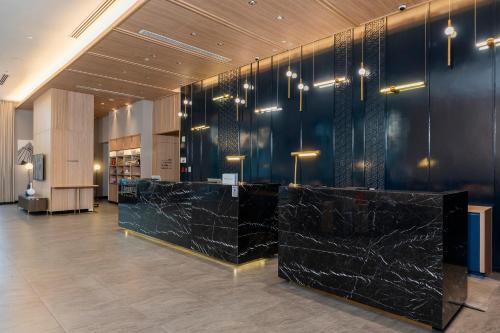a lobby with black marble counters in a building at Staybridge Suites Bangkok Thonglor by IHG in Bangkok