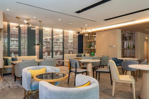 a restaurant with tables and chairs and windows at Staybridge Suites Bangkok Thonglor by IHG in Bangkok