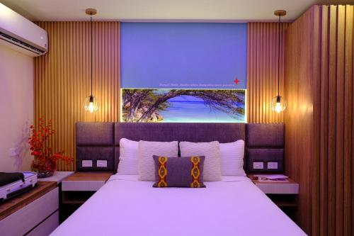 a bedroom with a large bed with a large window at Victoria City Hotel in Oranjestad