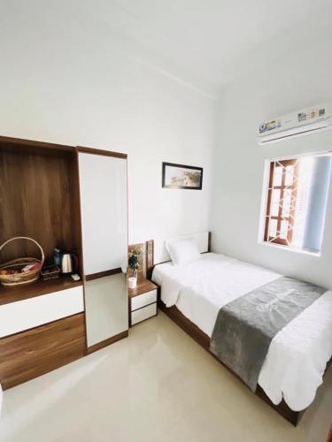 a white bedroom with a bed and a window at RiverView Homestay 2 in Xóm Ðé