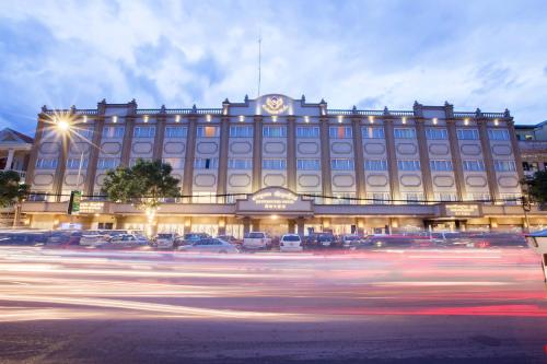 a large building with cars parked in front of it at Le President Hotel in Phnom Penh