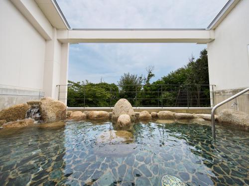 a pool of water in a building with a glass door at Hotel Holistic Resort Wakayama in Taiji