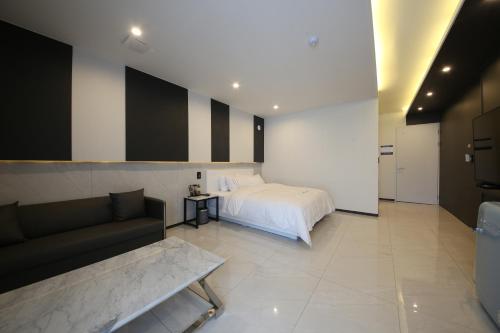 a hotel room with a bed and a couch at Calton Hill Hotel in Jeonju