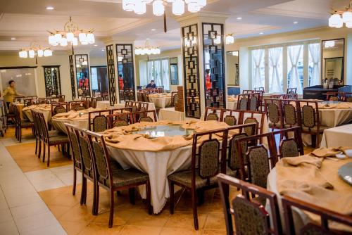 a dining room filled with tables and chairs at Le President Hotel in Phnom Penh