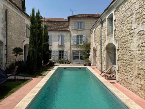 une piscine dans la cour d'un immeuble dans l'établissement Appartement historique avec piscine, salle de jeux, et jardin - idéal famille et amis - FR-1-653-261, à Angoulême