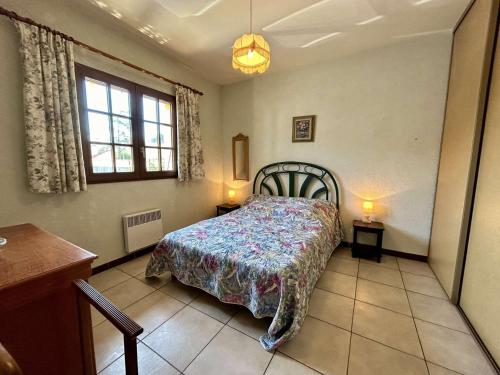 une chambre avec un lit et deux tables et une fenêtre dans l'établissement Villa familiale climatisée avec jardin, proche plage, parking, Wifi et barbecue - Saint-Cyprien - FR-1-225D-218, à Saint-Cyprien
