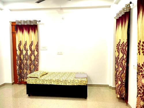 a small bed in a room with curtains at Green View Luxury Apartments in Varanasi