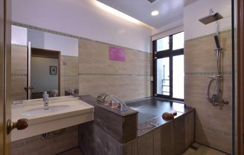 a bathroom with a sink and a shower at A-SAN Hot-Spring Hotel in Jiaoxi