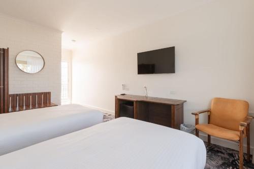 a bedroom with a bed and a desk and a television at Best Western Adelaide Airport in Adelaide