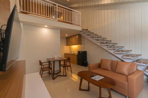 a living room with a couch and a staircase at Casa Residence Bali By Bali Cabin in Kerobokan
