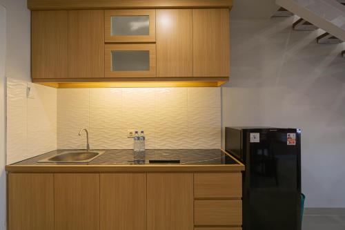 a kitchen with a sink and a black refrigerator at Casa Residence Bali By Bali Cabin in Kerobokan