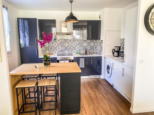 a kitchen with a table and some chairs in it at T3 Moderne avec balcon terrasse et parking gratuit in Niort