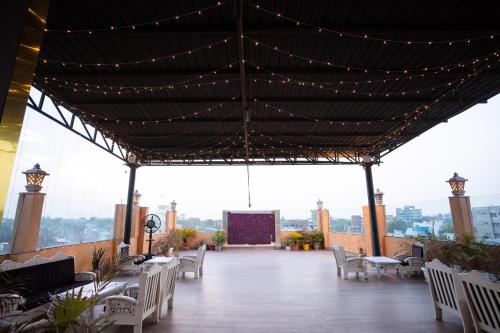 a pavilion with white tables and chairs and lights at Hotel Radiance Courtyard in Varanasi