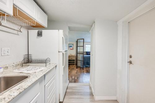 レイクランドにあるWalk to Lake Hunter Cozy Pet-Friendly Studio!の白いキャビネットと白い冷蔵庫のあるキッチン