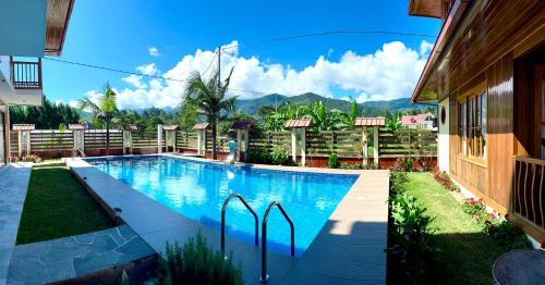 une piscine dans une cour à côté d'une maison dans l'établissement DCampos Lodge, à Oxapampa