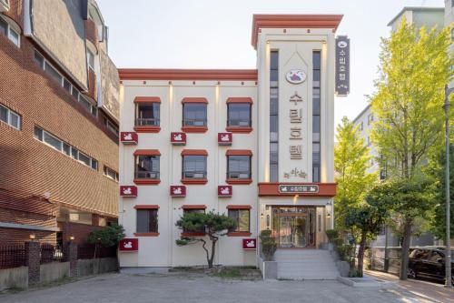 a white building with a sign in front of it at Surim Hotel Sokcho by AanK in Sokcho