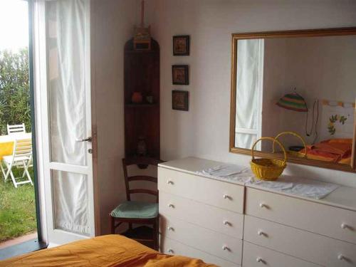 1 dormitorio con tocador, espejo y cama en Cà Gialla, en Bonassola