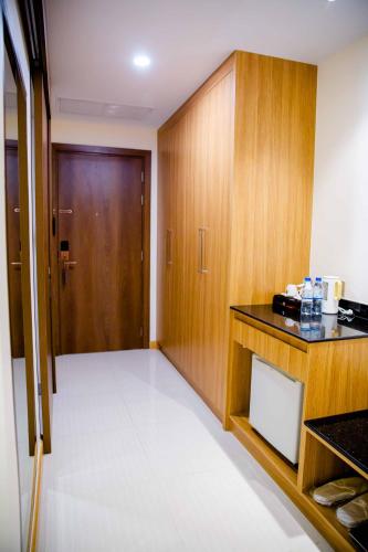 a room with a kitchen with wooden cabinets and a door at Le President Hotel in Phnom Penh