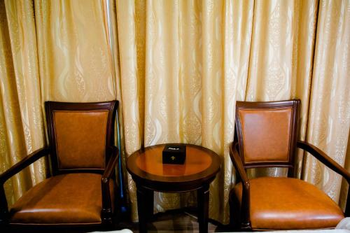 two chairs and a table in front of a curtain at Le President Hotel in Phnom Penh