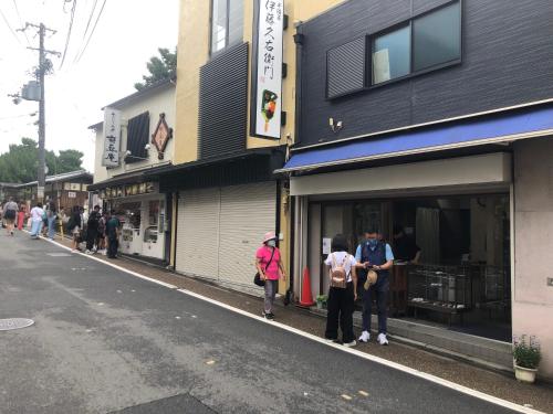 a group of people standing outside a store on a street at 静雅の宿 in Kyoto