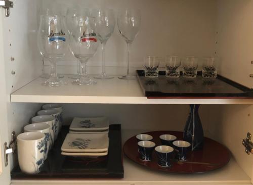 a shelf with wine glasses and plates and bowls at 静雅の宿 in Kyoto