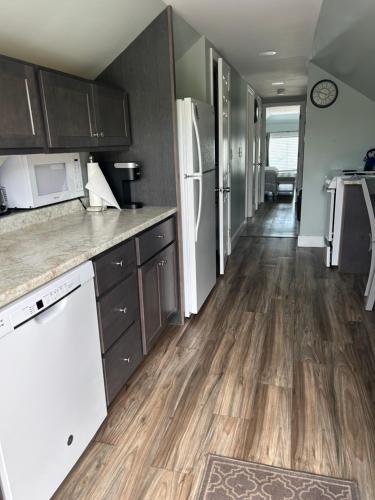 a kitchen with white appliances and a wooden floor at Sea Shell in Old Orchard Beach