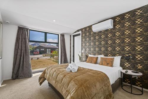 a bedroom with a bed and a large window at Luxury & Modern Living Home & Apartment in Queenstown