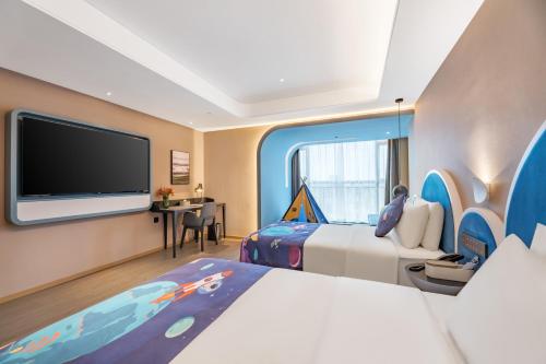 a hotel room with two beds and a flat screen tv at Atour Hotel Changsha Binjiang Financial Center in Changsha