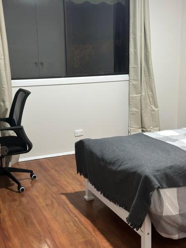a bedroom with a bed and a chair and a window at University lifestyle in Melbourne