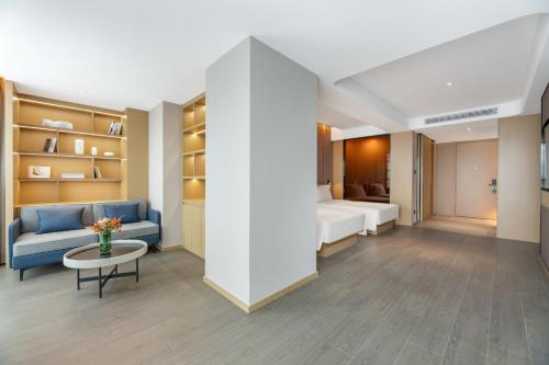 a room with a bed and a couch and a table at Atour Hotel Changsha Binjiang Financial Center in Changsha