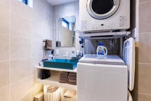 a bathroom with a sink and a washing machine at 宮城海岸まで2分 周辺には飲食店多数の北谷エリア セブンヴィレッジ2階 in Chatan