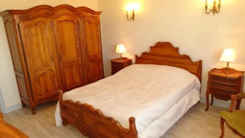 - une chambre avec un grand lit en bois et 2 tables de chevet dans l'établissement Villa de charme à Taillades avec piscine privée, à Les Taillades