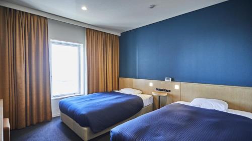 a hotel room with two beds and a window at Kansai Airport Washington Hotel in Izumi-Sano