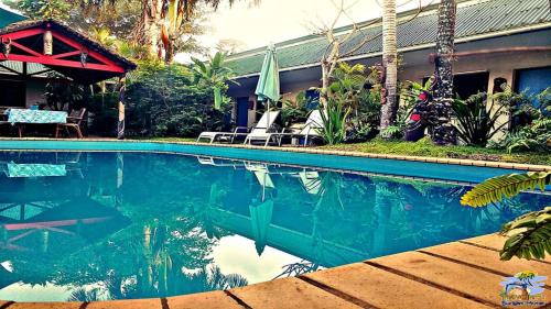 a swimming pool in front of a house at Travellers Motel Vanuatu in Port Vila