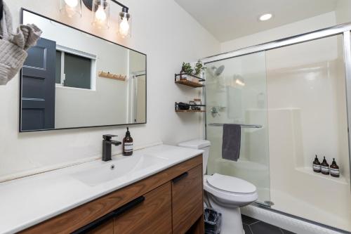 a bathroom with a sink and a toilet and a mirror at Walk to GC Train Depot and Route 66, king beds, game room, BBQ, firepit in Williams