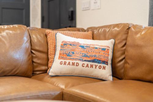 a brown leather couch with a pillow on it at Walk to GC Train Depot and Route 66, king beds, game room, BBQ, firepit in Williams