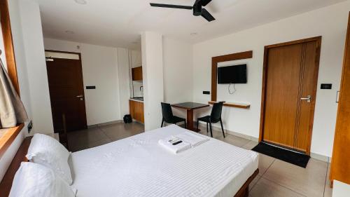 a bedroom with a bed and a table and a desk at Rose Garden at Rajagiri Hospital in Ernakulam