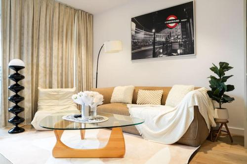 a living room with a couch and a glass table at Modern Urban Oasis in the Heart of Chinatown in Sydney