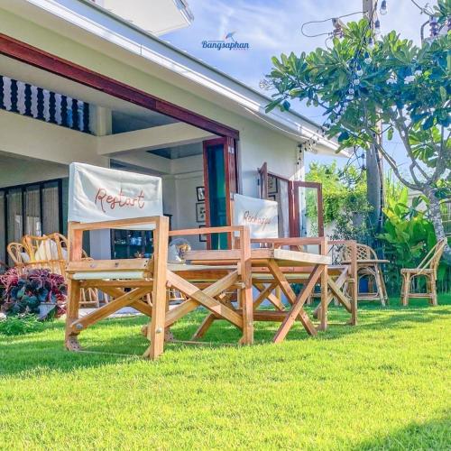 two wooden benches sitting outside of a house at Bangsaphan Resort in Bang Saphan