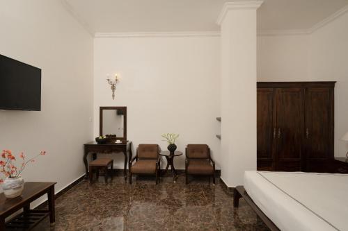 a living room with a bed and a table and chairs at The Manor Villas Da Lat in Xuan An