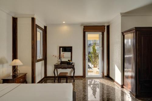 a bedroom with a bed and a table and a desk at The Manor Villas Da Lat in Xuan An